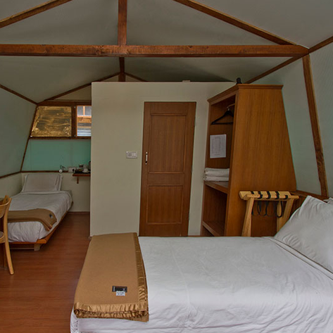 Ein gemütliches Zimmer im Ule Ethnic Resort, ausgestattet mit zwei Betten und einem Holzschreibtisch.