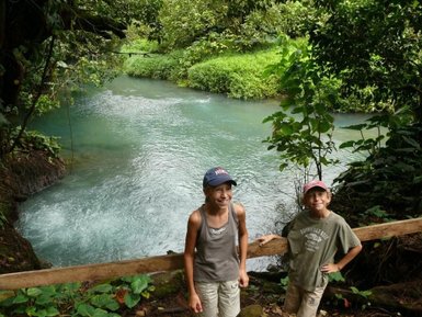 Fröhliche Kinder vor dem türkisblauen Rio Celeste – Costa Rica mit Kindern