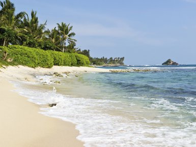 Glasklares Wasser schimmert in der Sonne an einem ruhigen Strand – Sri Lanka Reise mit Kindern