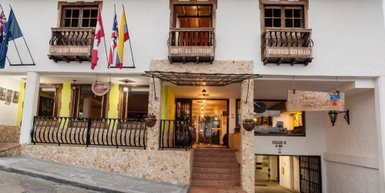 Die Fassade eines charmanten Hotels in Salento, Kolumbien, mit bunten Flaggen und einem einladenden Eingangsbereich.