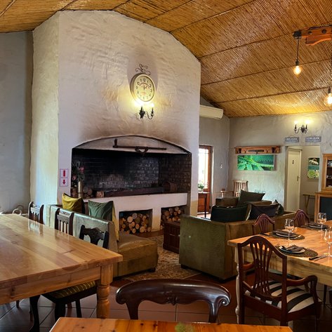 Ein einladender Essraum mit einem großen Holztisch, umgeben von stilvollen Stühlen und einer gemütlichen Sitzecke.