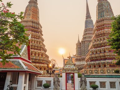 Sonnenuntergang über dem Wat Pho Tempel mit goldglänzenden Türmen – Thailand Reise mit Kindern