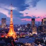 Der Tokyo Tower leuchtet in warmen Farben, während die Stadt unter einem dramatischen Abendhimmel erstrahlt.