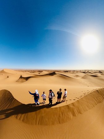 Familie steht in Sanddünen der Sahara - Marokko mit Kindern