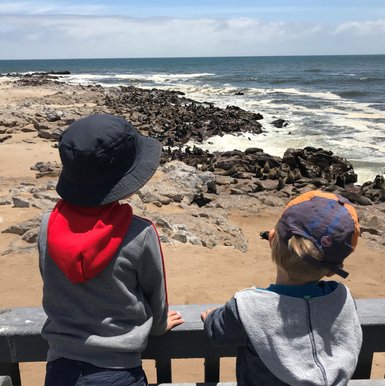 Zwei Kinder beobachten eine Robbenkolonie - Namibia mit Jugendlichen