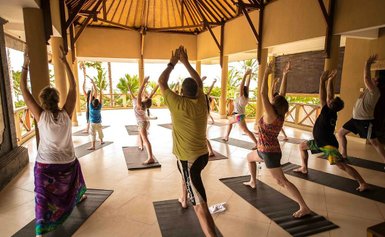 Erwachsene und Eltern üben Yoga in einem Kurs auf Bali – Bali mit Kindern