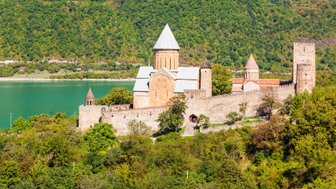 Die beeindruckende Ananuri-Festung thront majestätisch über dem smaragdgrünen Wasser des Stausees, umgeben von üppigem Grün.