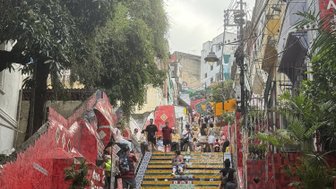 Die bunten Fliesen der Treppe sind mit zahlreichen Menschen belebt, die den Aufstieg in die lebendige Atmosphäre der Umgebung genießen.