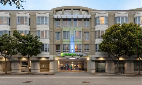 Das Holiday Inn Express in San Francisco zeigt eine moderne Fassade mit großen Fenstern und grünen Akzenten.