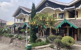 Ein malerisches Lodge-Gebäude mit bunten Dächern und üppiger Vegetation umgibt den einladenden Innenhof.