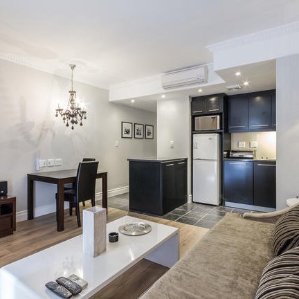 Ein modernes Wohnzimmer mit einem bequemen Sofa, einem Couchtisch und einem Fernseher, das eine einladende Atmosphäre schafft.