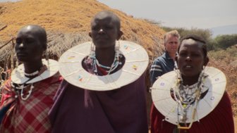 Drei Massai-Frauen in traditioneller Kleidung im Dorf – Tansania mit Kindern