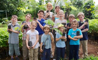 Gruppe von Kindern mit Mini-Bäumen zum Pflanzen – Costa Rica mit Kindern