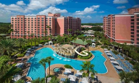 Ein Blick auf den großzügigen Poolbereich des Caribe Royal Resorts, umgeben von Palmen und Sonnenliegen unter klarem Himmel.