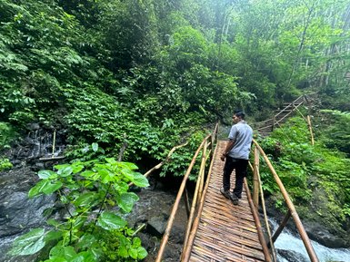 Guide steht auf einer Brücke und führt durch die Landschaft beim Munduk Walk – Bali Reise mit Kindern