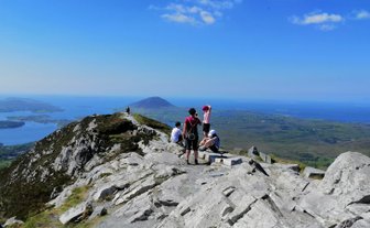 Eine Gruppe von Wanderern genießt die atemberaubende Aussicht auf die Küste und das grüne Land von Connemara.