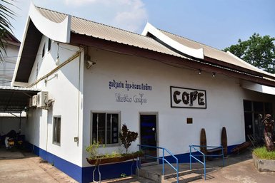 Das COPE Besucherzentrum ist ein modernes Gebäude mit einem markanten Dach und einer einladenden Fassade in Laos.