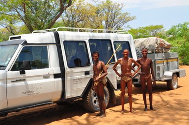 Einheimische stehen direkt neben einem Jeep in der Sonne - Namibia mit Kindern