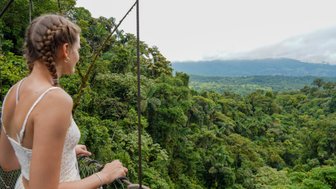 Teenagerin blickt auf die üppige Natur im Mistico Arenal Hanging Bridges Park – Costa Rica mit Kindern