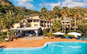Ein sonniger Tag am Hotel Aktea auf Lipari, umgeben von Palmen und einem einladenden Poolbereich.