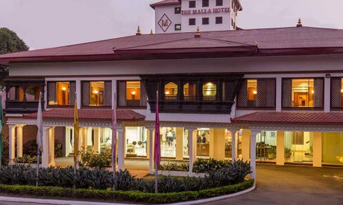 Das Malla Hotel in Nepal zeigt eine elegante Fassade mit traditioneller Architektur und einladenden Fenstern.