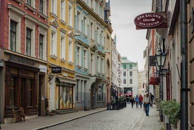 Eine malerische Straße in Riga mit bunten Gebäuden und Fußgängern, die die charmante Atmosphäre genießen.