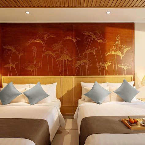 Ein stilvolles Schlafzimmer mit zwei Betten, dekoriert mit blauen Kissen und einer kunstvollen Wandgestaltung aus Blumen.