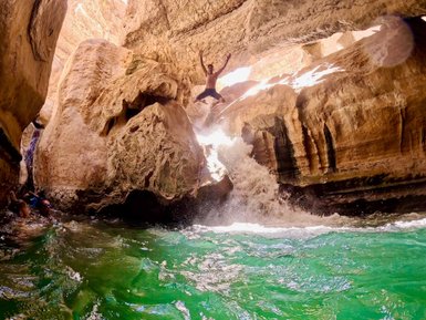 Junge springt ins Wasser im Wadi Shab im Oman – Oman mit Kindern