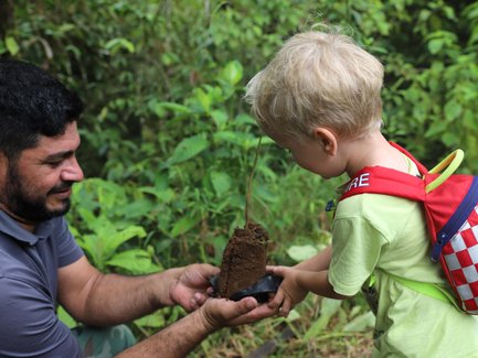 Kleinkind und Guide beim Baumpflanzen in La Tigra – Costa Rica Familienreise