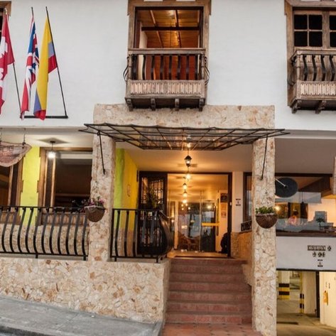 Die Fassade eines charmanten Hotels in Salento, Kolumbien, mit bunten Flaggen und einem einladenden Eingangsbereich.