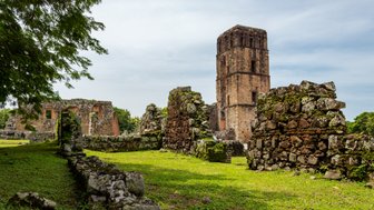 Die Ruinen von Panama Viejo zeigen alte Steingebäude, umgeben von üppigem Grün und einem klaren Himmel.