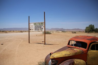Ein rostiges Auto steht verlassen in der Wüste - Namibia mit Kindern