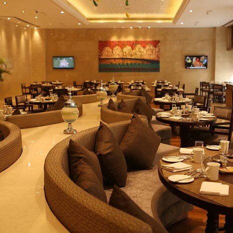Elegante Restaurant mit runden Tischen, gemütlichen Sitzgelegenheiten und stilvollen Dekorationen, ideal für gesellige Abende.