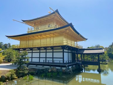 Der goldene Tempel in Kyoto spiegelt sich majestätisch im ruhigen Wasser eines umgebenden Teichs wider.