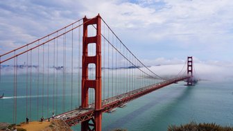 Die Golden Gate Bridge erstreckt sich majestätisch über das Wasser, umgeben von sanften Nebelschwaden und einer ruhigen Küstenlandschaft.