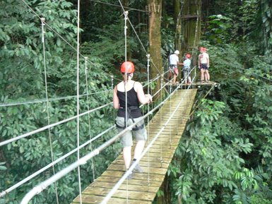 Frau geht über eine Hängebrücke beim Canopy-Abenteuer im Dschungel – Costa Rica Reise mit Kindern