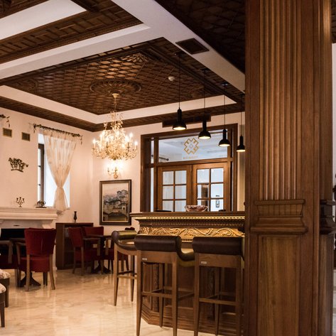 Der elegante Empfangsbereich des Hotels zeigt eine stilvolle Einrichtung mit Holzdetails und einem Kronleuchter.