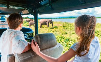 Kinder blicken neugierig aus dem offenen Jeep bei einer Safari im Udawalawe-Nationalpark – Sri Lanka Familienreise