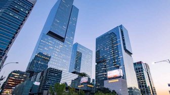 Hochmoderne Wolkenkratzer erheben sich majestätisch gegen den Abendhimmel in Gangnam, Seoul, umgeben von urbanem Leben.