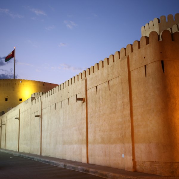 Festung von Nizwa beleuchtet bei Nacht im Oman – Oman Reise mit Kindern