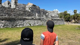 Zwei Kinder stehen vor den gut erhaltenen Ruinen in Tulum – Mexiko Familienreise