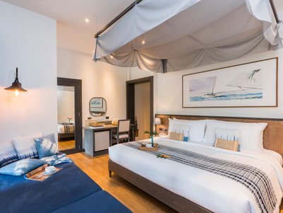 Ein stilvolles Hotelzimmer mit einem großen Bett, einem gemütlichen Sofa und einem Schreibtisch, ideal für Entspannung.