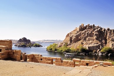 Die stillen Wellen des Nils reflektieren die umliegenden Felder und die majestätischen Felsen in Ägypten.
