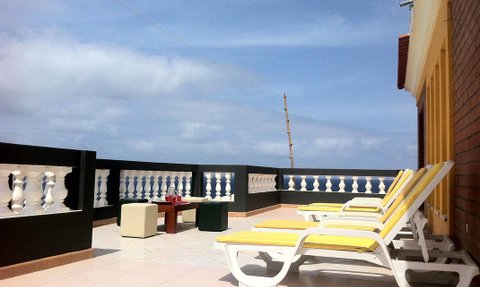 Ein sonniger Terrassenbereich mit bequemen Liegen und gemütlichem Tisch, ideal für Entspannung mit Meerblick.