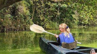 Mädchen paddelt entspannt auf dem ruhigen Wasser – Tansania mit Kindern