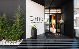Der Eingangsbereich des Chic Boutique Hotels zeigt moderne Architektur mit eleganten Pflanzen und einem einladenden Ambiente.