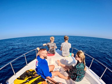 Familie im Boot auf dunkelblauem Wasser bei den Daymaniyat Inseln – Oman Familienreise