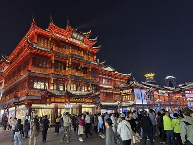Die beeindruckende Architektur der beleuchteten Altstadt strahlt in warmen Rottönen und zieht eine große Menschenmenge an.