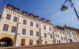 Die Fassade eines eleganten Hotels mit großen Fenstern und einem klaren blauen Himmel im Hintergrund.