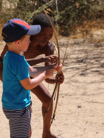 Ein Kind versucht einen Bogen zu spannen - Namibia Urlaub mit Kindern